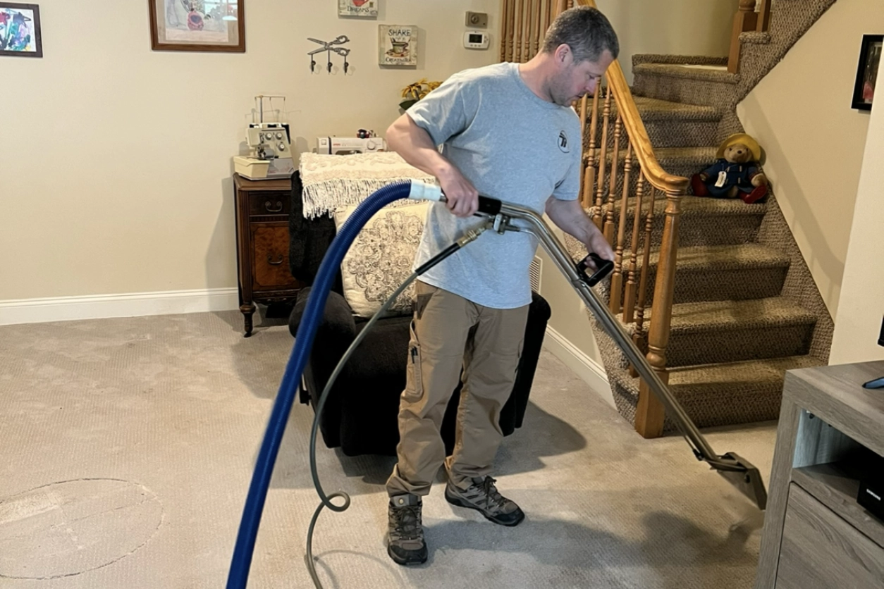 A man is cleaning the floor with two hoses.